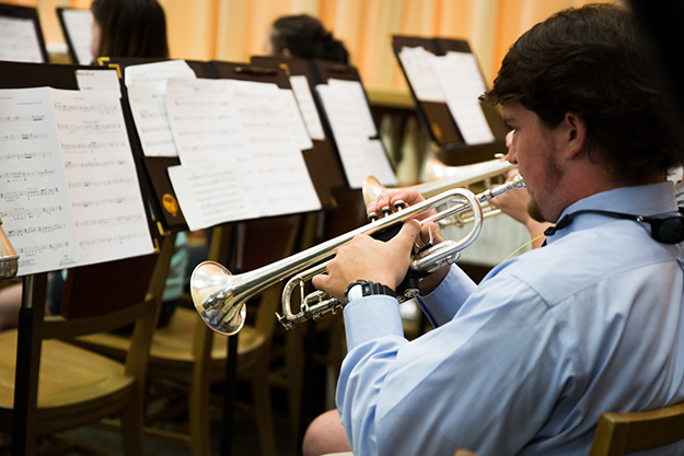 male student playing the trumpet at band practice