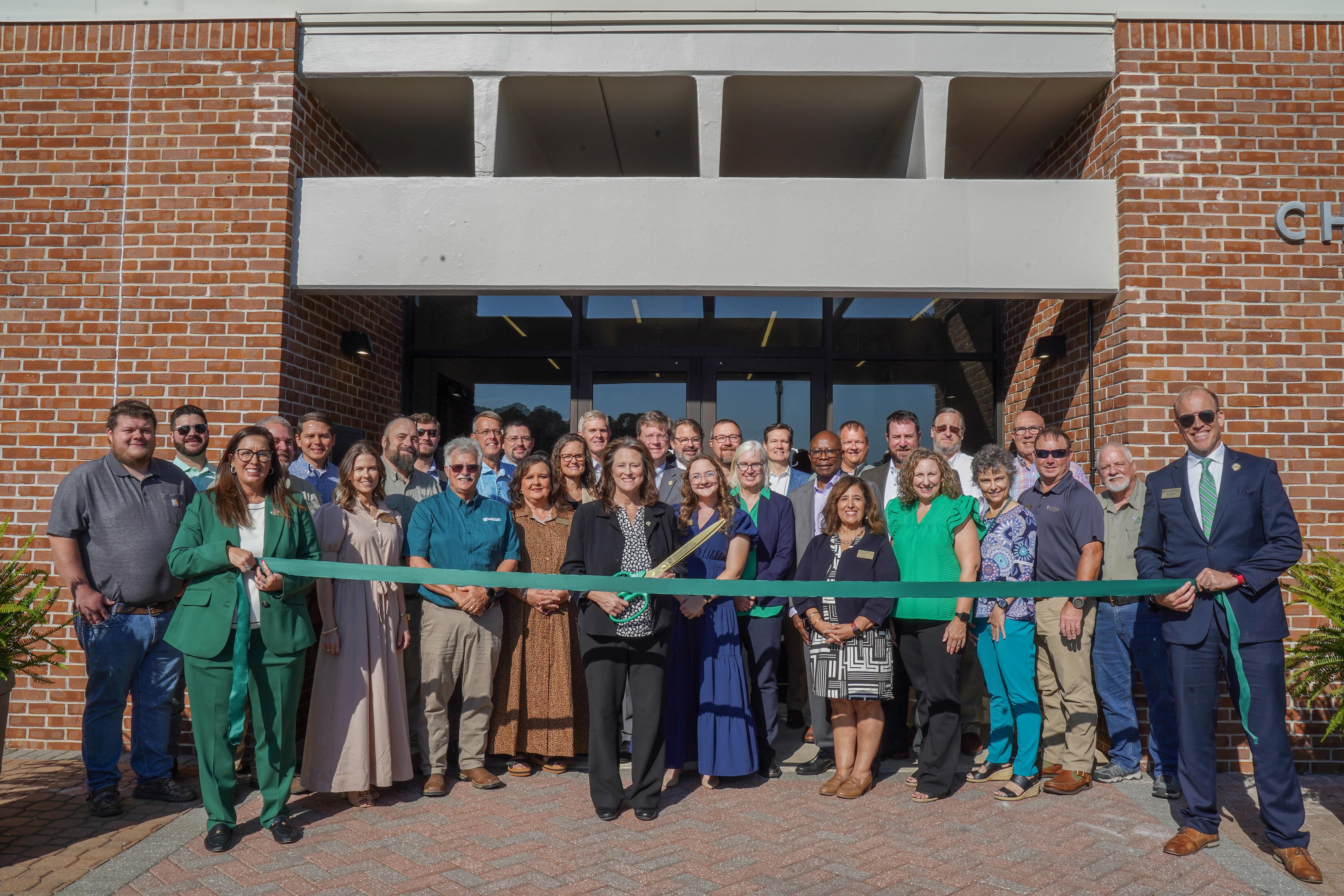 Photo of ABAC representatives holding the ribbon for cutting. 