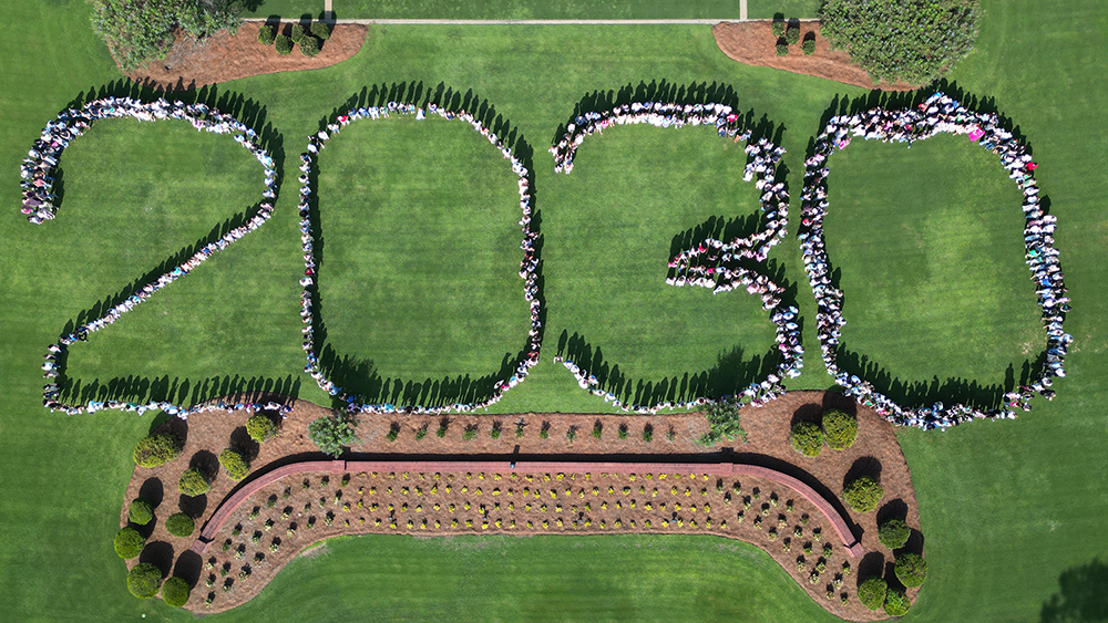 students standing in the shape of 2023