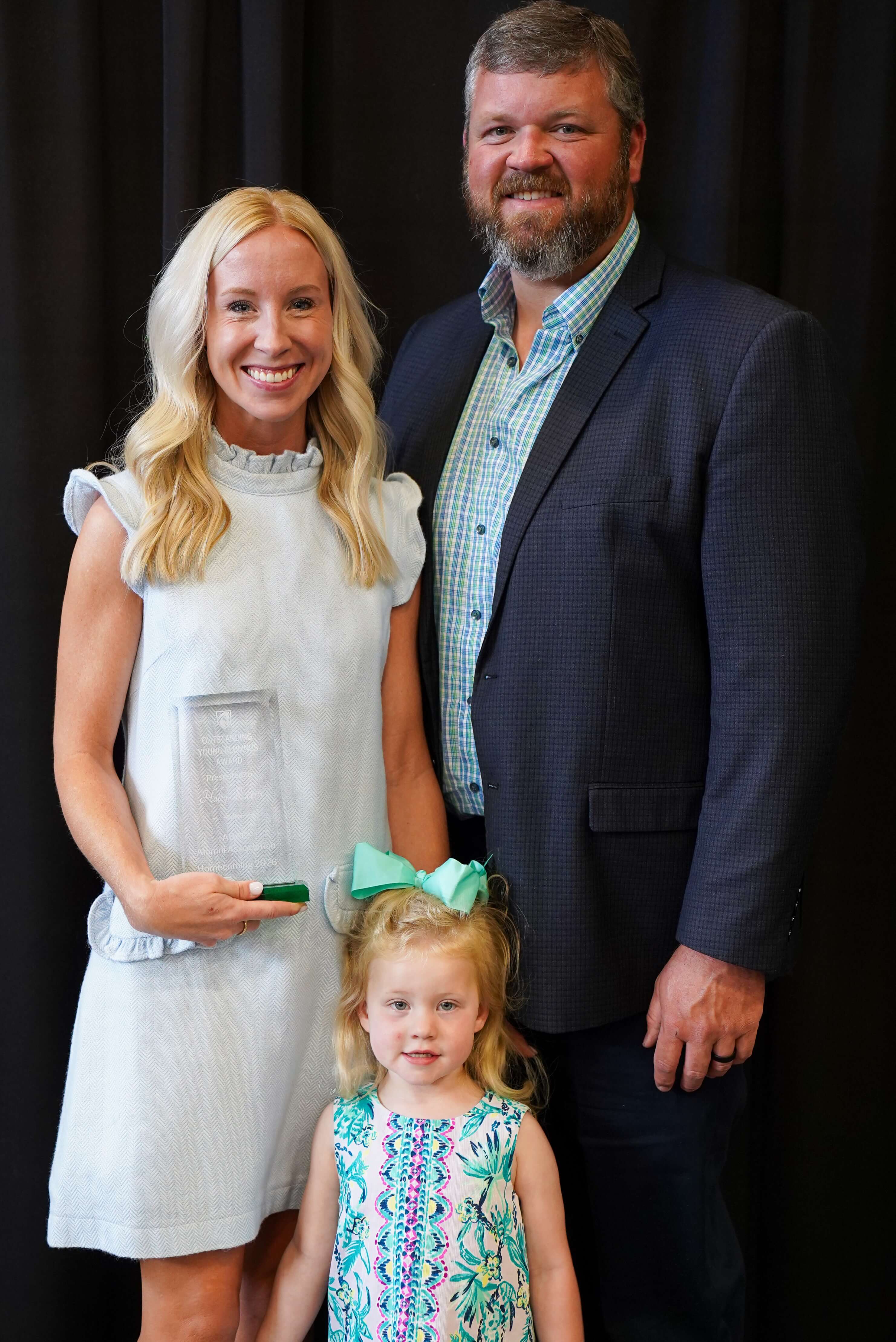 woman and family holding award.