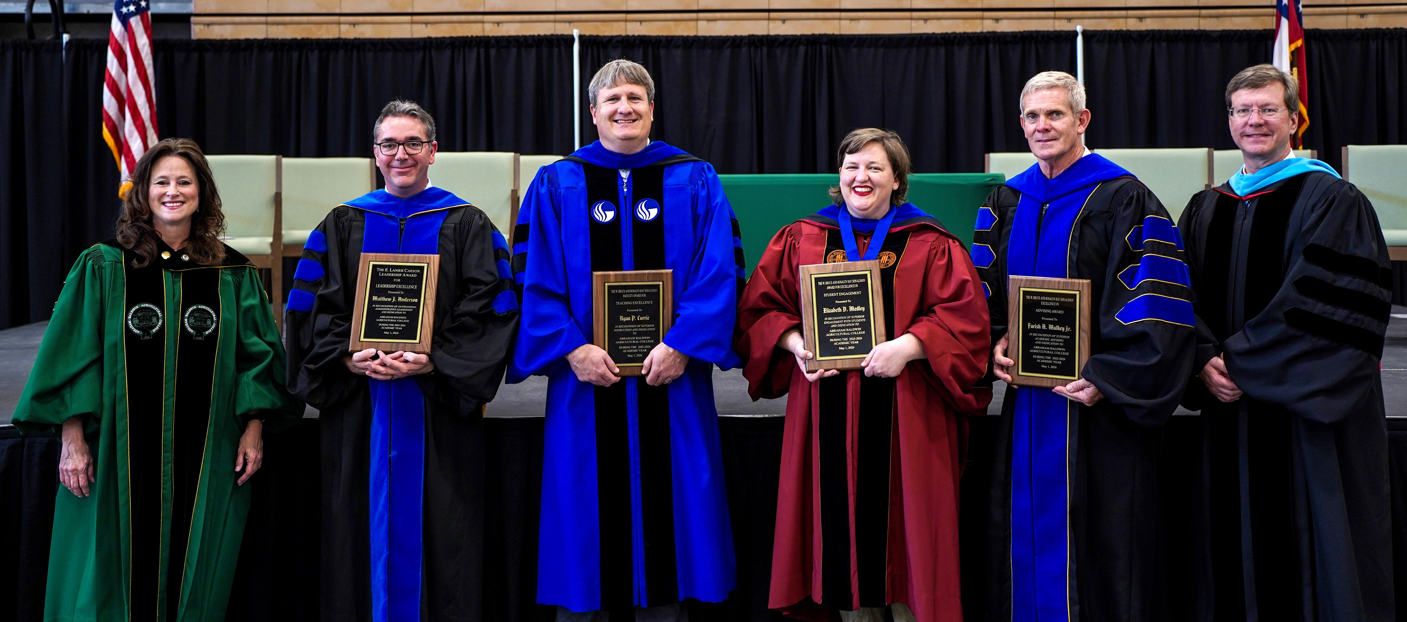 five people posing for a group photo at an award ceremony