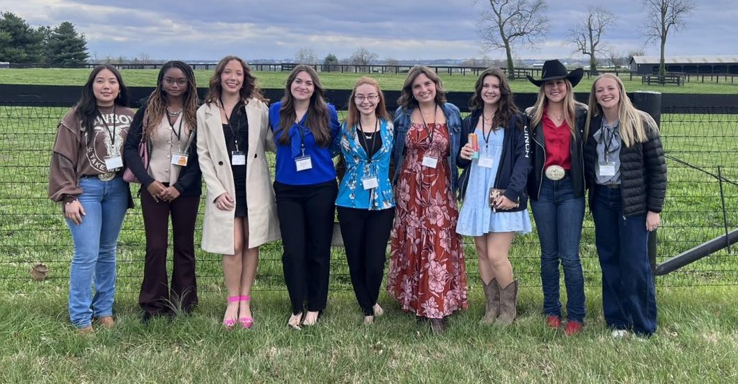 students standing in a row in a field.