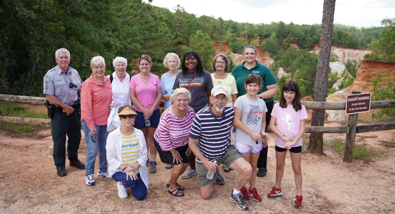 Group of travelers stand in front of the edge of Providence Canyon